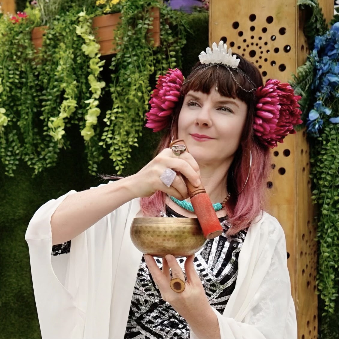 Chris holding a singing bowl during a community sound healing event