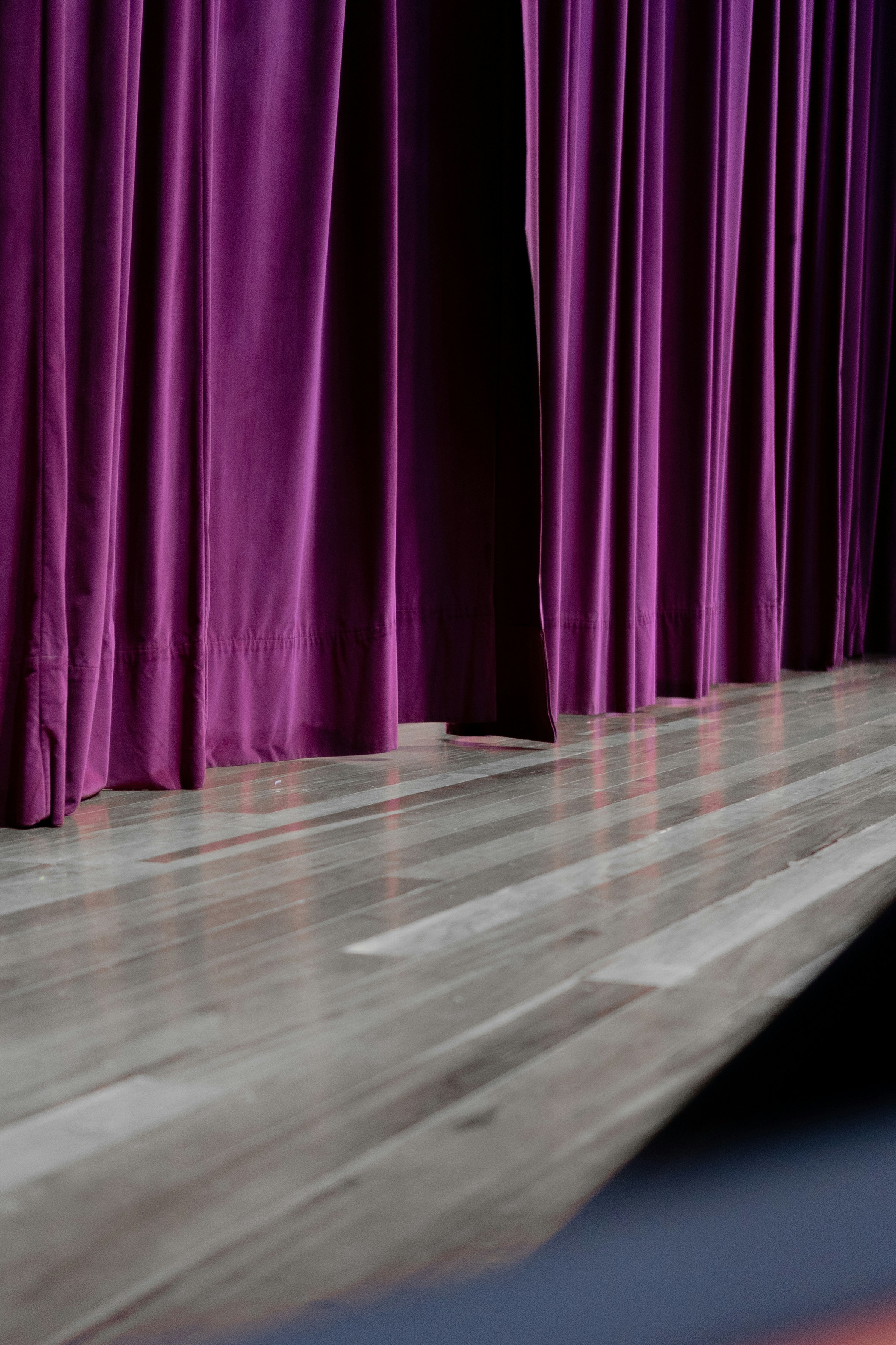 Purple stage curtains and a lit stage floor